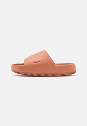 Nike slaidu sandalītes maigā persiku gumijā, ar plašu augšējo siksnu ar logotipa detaļu un teksturētu zoli labākai saķerei.