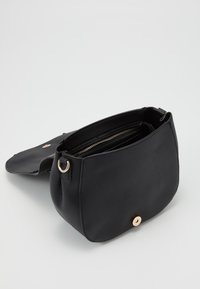 Borsa in pelle nera con forma arrotondata, interno con cerniera, chiusura a patta piatta e dettagli in metallo dorato. Superficie testurizzata.