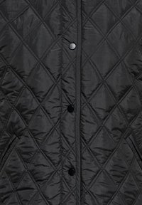 Czarna pikowana kurtka z przeszyciami w kształcie diamentów, zatrzaskami na środku i skośnymi kieszeniami po bokach.