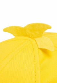 Helle gelbe Stoffmütze mit drei weichen Filzspitzen, die oben herausragen und an Dinosaurier- oder Drachenstacheln erinnern.