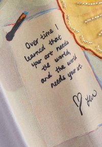 Ručne písaná správa znie: „"Over time I learned that your art needs the world, and the world needs your art,"“ srdcom a podpisom nižšie.