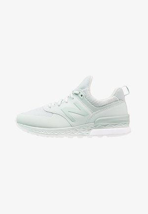 Baskets de sport gris clair avec tige en mesh, semelle rembourrée, fermeture à lacets et un logo "N" proéminent sur le côté.