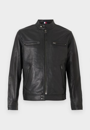 Czarna skórzana kurtka z kołnierzem stojącym, zamkiem błyskawicznym z przodu oraz dwiema kieszeniami na zamek błyskawiczny na piersiach. Gładka faktura oraz dopasowany krój.