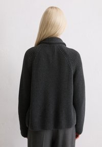 Gestrickter, dunkelgrauer Pullover mit hohem Kragen, gerippter Textur, überschnittenen Schultern und lässiger Passform. Verfügt über einen geraden Rücken und lange Ärmel.