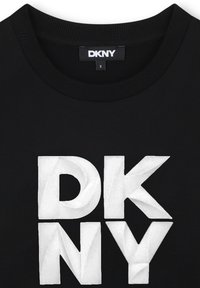 Sweatshirt noir avec un col côtelé présentant un grand logo "DKNY" en relief blanc. Tissu doux avec une texture lisse et des bords nets.