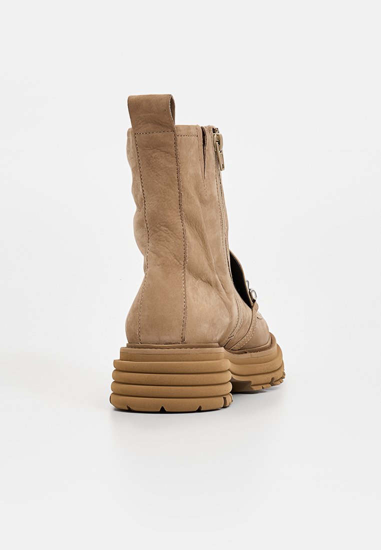 Braune Leder-Stiefelette mit profiliertem Chunky-Sohle, seitlichem Reißverschluss und strukturiertem Finish. Mit runder Ferse und minimalen Nähdetails.