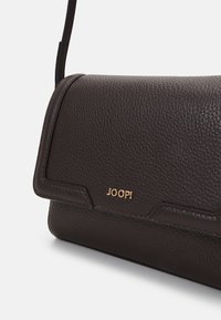 Borsa a spalla in pelle marrone con finitura testurizzata, dotata di un accento in logo dorato e chiusura a patta. Cinghia attaccata per una facile vestibilità.