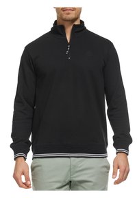 Svart zip-up hettegenser med høy krage, ribbede mansjetter og søm, med hvite horisontale striper nederst. Glatt stoff tekstur.