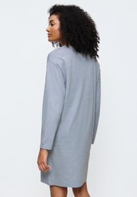 Abito lungo grigio in cotone a maniche lunghe con vestibilità rilassata, con un collo a giro semplice e un delicato dettaglio di design sul retro.