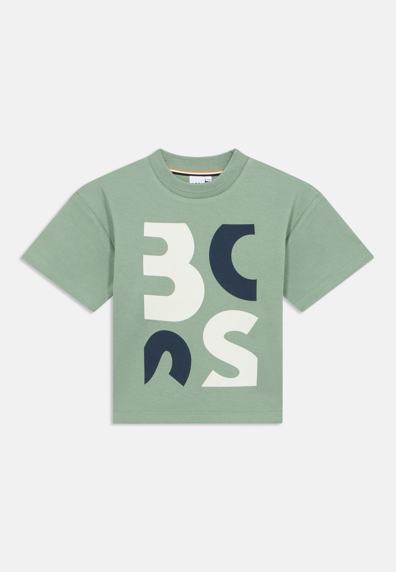 T-shirt en coton vert clair avec un col rond, présentant de grandes formes abstraites en blanc et bleu marine. Manches courtes, coupe décontractée.