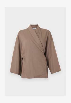 Haut marron style cache-cœur à manches longues avec larges manches et col croisé, présenté sur fond blanc uni.