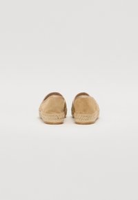 Smėlio spalvos suknelės espadrilės su audiniu iš jutos ir subtiliais elastingumo elementais ant kulno, užtikrinančios minimalistinį dizainą ir patogų prigludimą.