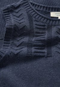 Suéter de punto azul marino con un patrón texturizado que presenta líneas diagonales y horizontales. Cuello y puños acanalados, hecho de un material orgánico suave.