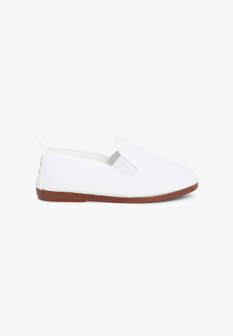 Chaussure blanche sans lacets avec panneaux latéraux élastiques et semelle plate marron, vue du côté extérieur sur fond blanc.