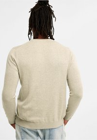  Licht beige lange mouwen trui gemaakt van zacht materiaal, met een geribbelde halslijn en manchetten, met een relaxte pasvorm en een eenvoudige ontwerpen.