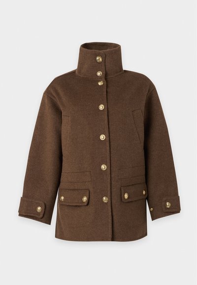 Veste en laine marron avec col haut, boutons dorés sur le devant, sur les poches et les poignets, exposée sur un fond clair uni.