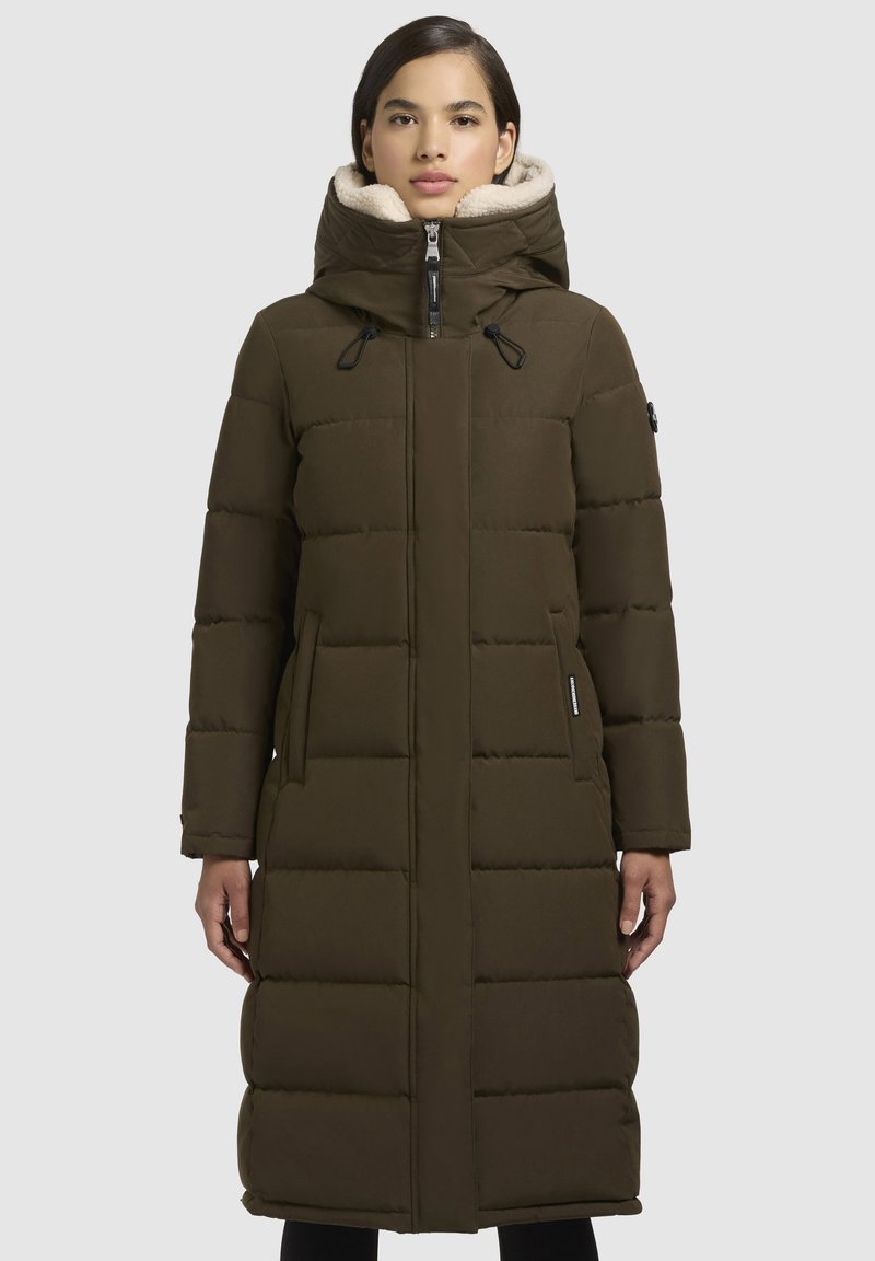 Długi oliwkowy puchowy płaszcz z kapturem, z miękkim futerkiem na kołnierzu, z zamkiem z przodu i dwoma bocznymi kieszeniami.