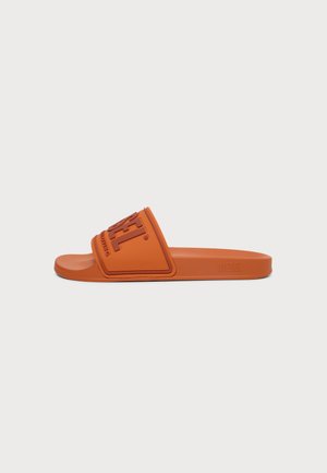 Πορτοκαλί σανδάλι τύπου slip-on με φαρδιά λωρίδα που διαθέτει ανασηκωμένο λογότυπο Diesel, επίπεδη σόλα και ανοιχτό σχέδιο στη μύτη, πάνω σε απλό φόντο.