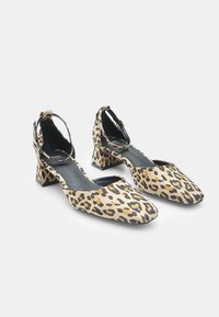 Leopard-print heels with a square toe, ankle strap, and low block heel. Made from soft fabric with a smooth texture and black accents.