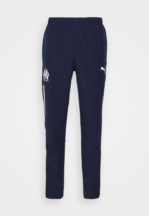 Pantalon de sport bleu marine avec taille élastique, logo du club de football de Marseille sur la cuisse gauche, logo Puma sur la cuisse droite et bandes latérales.