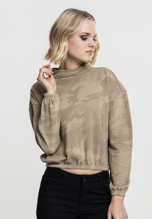 Beige cropped sweatshirt med camouflage-mønster, lange ermer og høy hals. Myk stoff med elastiske mansjetter og hem.