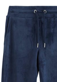 Dunkelblaue Jogginghosen aus weichem Stoff mit glatter Textur, elastischem Bund und verstellbaren Kordeln mit metallischen Enden.
