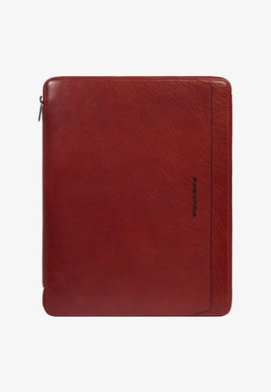 Étui fin pour tablette ou ordinateur portable en cuir rouge avec fermeture éclair tout autour et logo de marque vertical discret sur le côté droit.