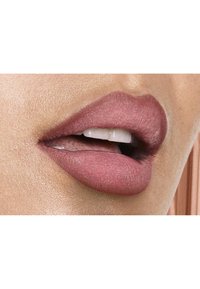 Matte mauve lippenstift op zachte, bleke lippen, die de gladde textuur benadrukt. Natuurlijk licht benadrukt de vorm van de lippen en de subtiele glans rond de randen.
