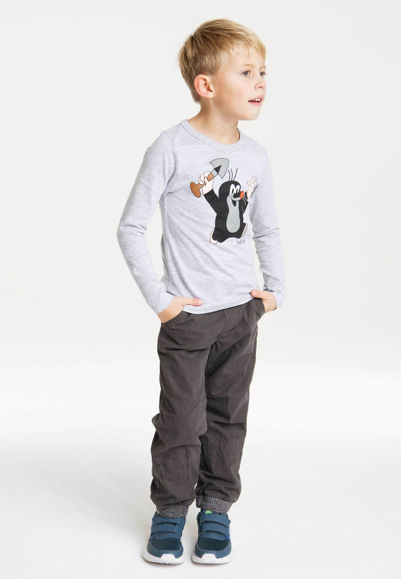 Gray long-sleeve t-shirt with a cartoon mole graphic; paired with dark gray pants and blue sneakers featuring green accents.
