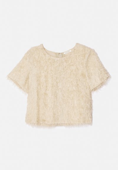 Šviesiai bežinis trumpų rankovių, trumpas viršus, su pūkuota tekstūra ir apvaliu iškirpimu, su paslėptu užtrauktuku nugarinėje pusėje.