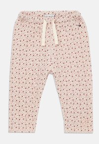 Jogginghose aus Baumwollmischung mit cremefarbener Hintergrund und rotem Blumenmuster. Mit elastischem Bund und Kordelzug.