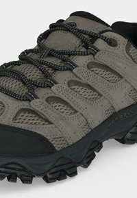 Chaussure de randonnée grise et noire avec panneaux en mesh, semelle noire robuste, coutures soignées et lacets noirs à motifs, marque Merrell sur le côté.