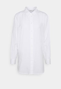 Camicia bianca a maniche lunghe in cotone. Presenta un colletto classico, chiusura con bottoni e polsini arricciati con una vestibilità leggermente ampia.
