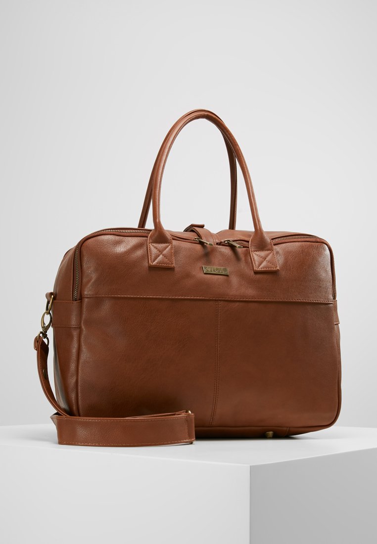 Borsa per laptop in pelle marrone con doppi manici, tracolla removibile, chiusura con zip e dettagli di cucitura sottili. Texture liscia, forma rettangolare.