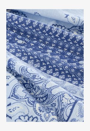 Niebieska tkanina w wzory, prezentująca skomplikowane motywy paisley i kwiatowe w różnych odcieniach, o gładkiej strukturze i jasnych guzikach.