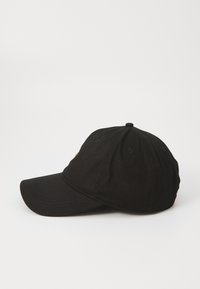 Black baseball cap made of cotton with a curved brim, featuring a yellow logo on the front and six rows of stitched detailing on the crown.