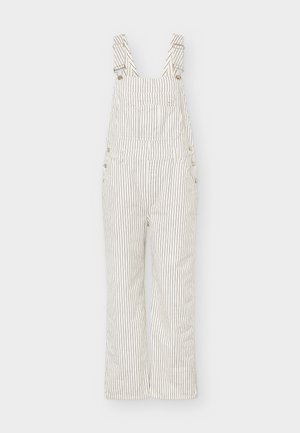 Λευκή ντένιμ ολόσωμη φόρμα με λεπτές κάθετες μαύρες ρίγες, ρυθμιζόμενους ιμάντες ώμου και μπροστινή τσέπη στο στήθος.