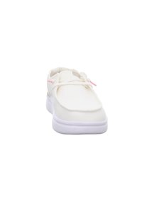 Baskets blanches avec une tige en toile, accents roses sur les lacets, semelle texturée et design à bout arrondi. Forme simple et profil bas.