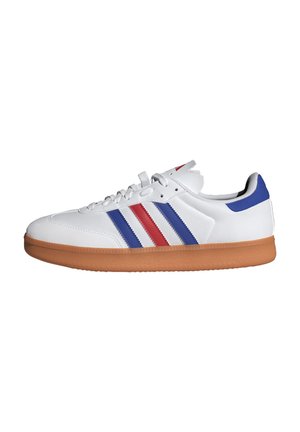 Baskets en cuir blanc avec semelle en caoutchouc couleur caramel, ornées de bandes parallèles bleues et rouges sur le côté et d'un accent bleu sur le talon.