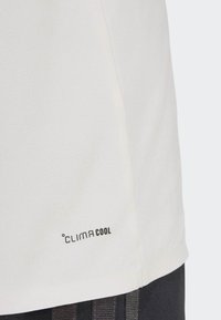 Close-up of a white fabric section with "CLIMACOOL" printed in black near the hem, paired with dark textured material below.