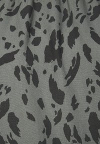 Tessuto grigio con un motivo astratto a macchie di leopardosnero, caratterizzato da macchie di dimensioni variabili e una superficie liscia e leggermente strutturata.