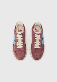 Fialové semišové tenisky s svetlo modrými akcentmi, krémovými šnúrkami a textúrovanými detailmi. Obsahujú gumovú podrážku a minimalistický dizajn.