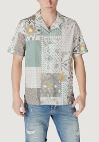Camisa de botones de manga corta con un diseño de patchwork en gris claro, verde azulado, naranja y blanco, que presenta patrones florales y geométricos.