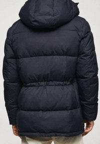 Granatowa kurtka puchowa z odczepianym kapturem, posiada poziome pikowane sekcje, elastyczną talię i matowe wykończenie.