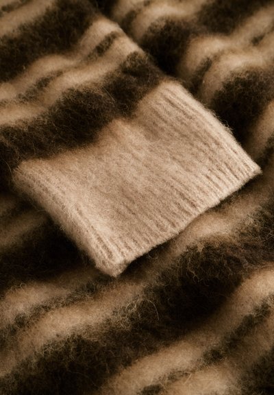 Tissu en laine rayé marron et beige avec une surface douce et texturée ; présente une section beige côtelée, indiquant un design confortable.