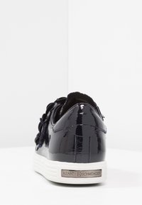 Baskets en cuir verni bleu marine avec semelle en caoutchouc blanche, design à lacets et accent logo métallique au niveau du talon. Fini texturé.