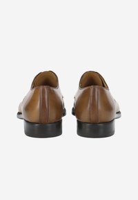 Chaussures en cuir marron à finition lisse, bout arrondi et petit talon noir. Design simple sans motifs ni accessoires visibles.