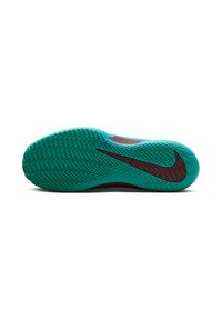 Türkisfarbener Gummischuhsohle mit Fischgrätenmuster, schwarzer Nike-Swoosh-Akzent und roten Details an der Seite. Insgesamt schlankes und modernes Design.
