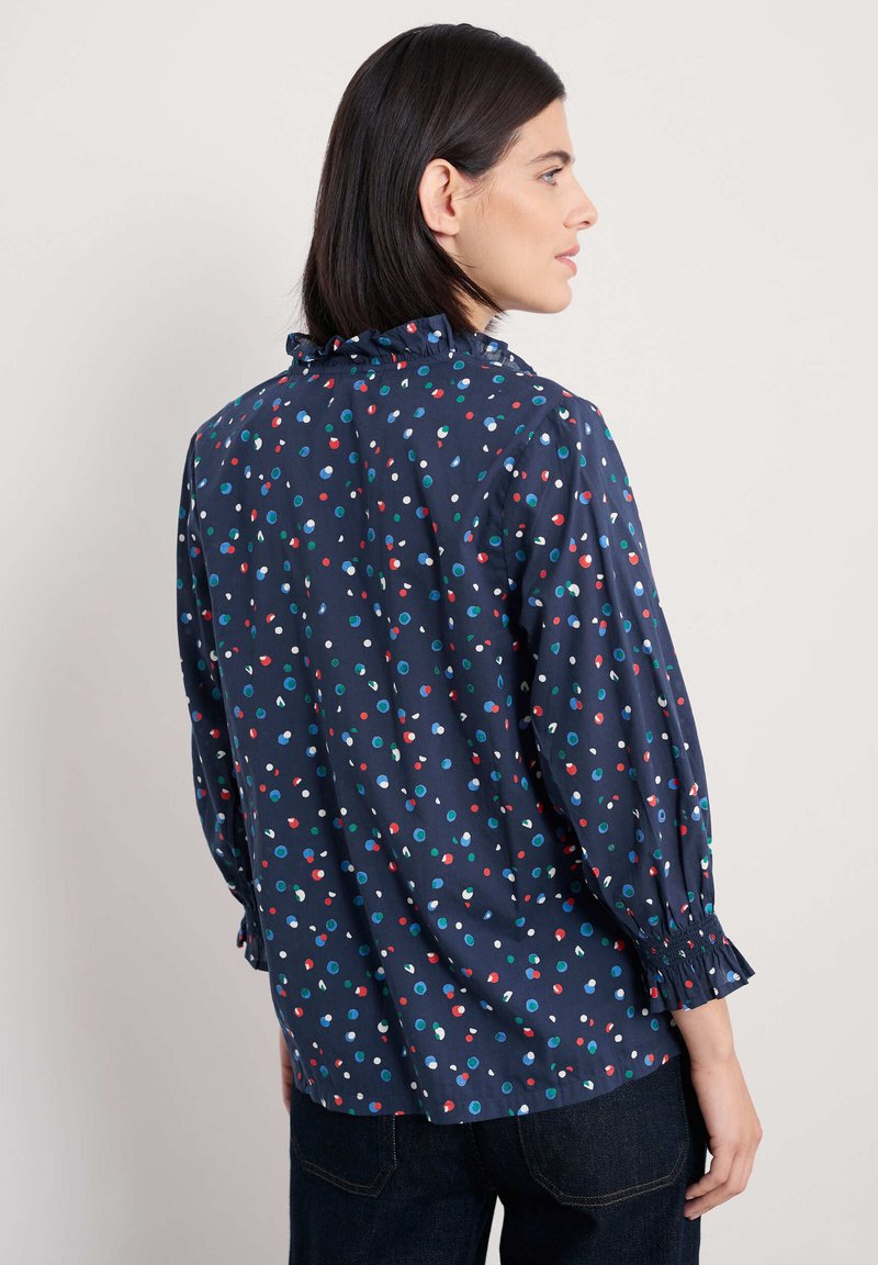 Marineblauw shirt met multicolore stippen, gerimpelde halslijn, elastische manchetten en een ontspannen pasvorm. Soepele stof, casual ontwerp.
