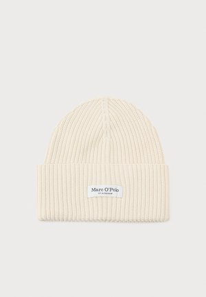 Cream-colored knit beanie with a ribbed texture. Features a rolled cuff and a stitched brand label on the front. Lightweight and flexible.